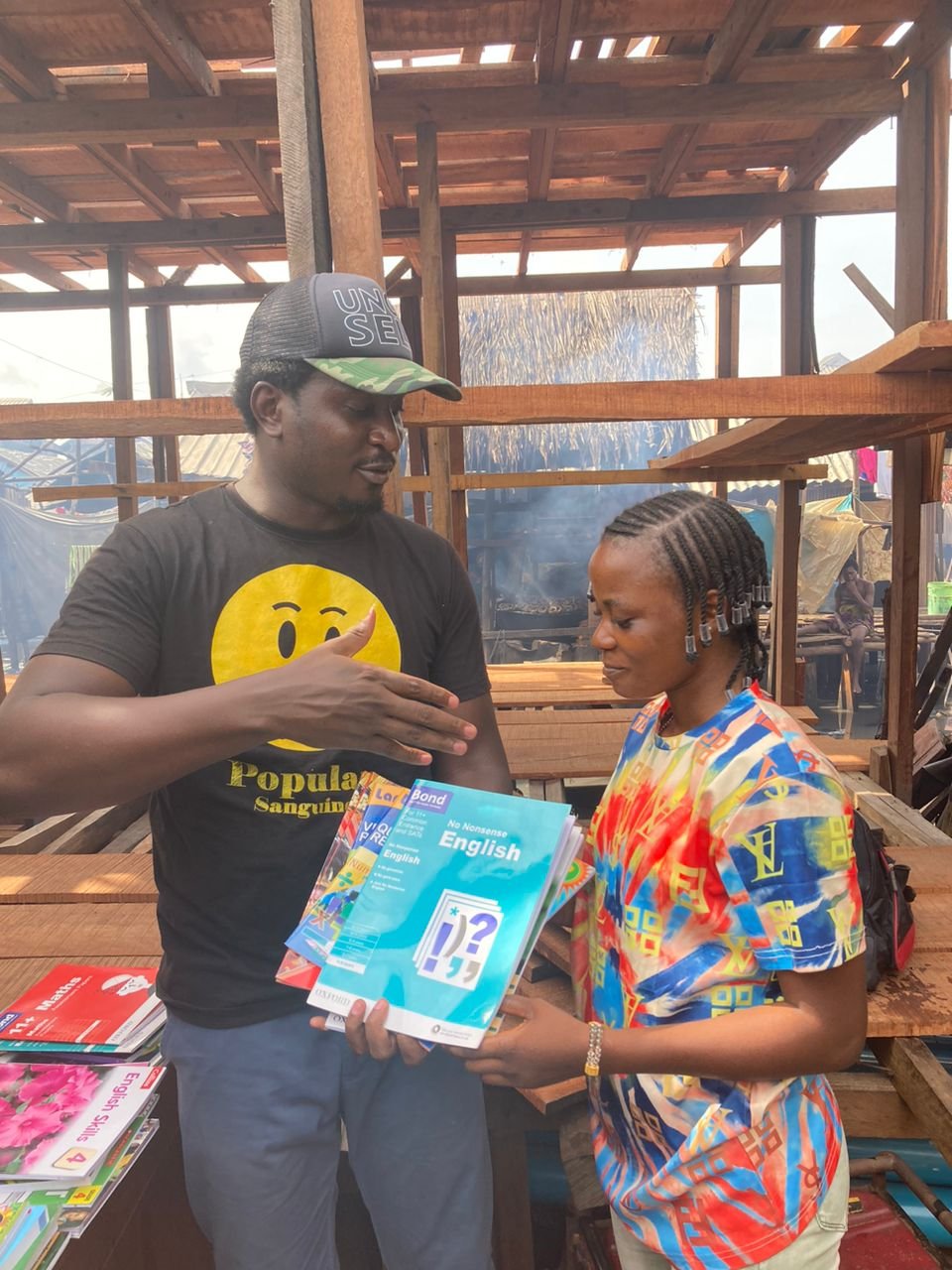 Uncle Sele Foundation representative supporting a student with learning materials