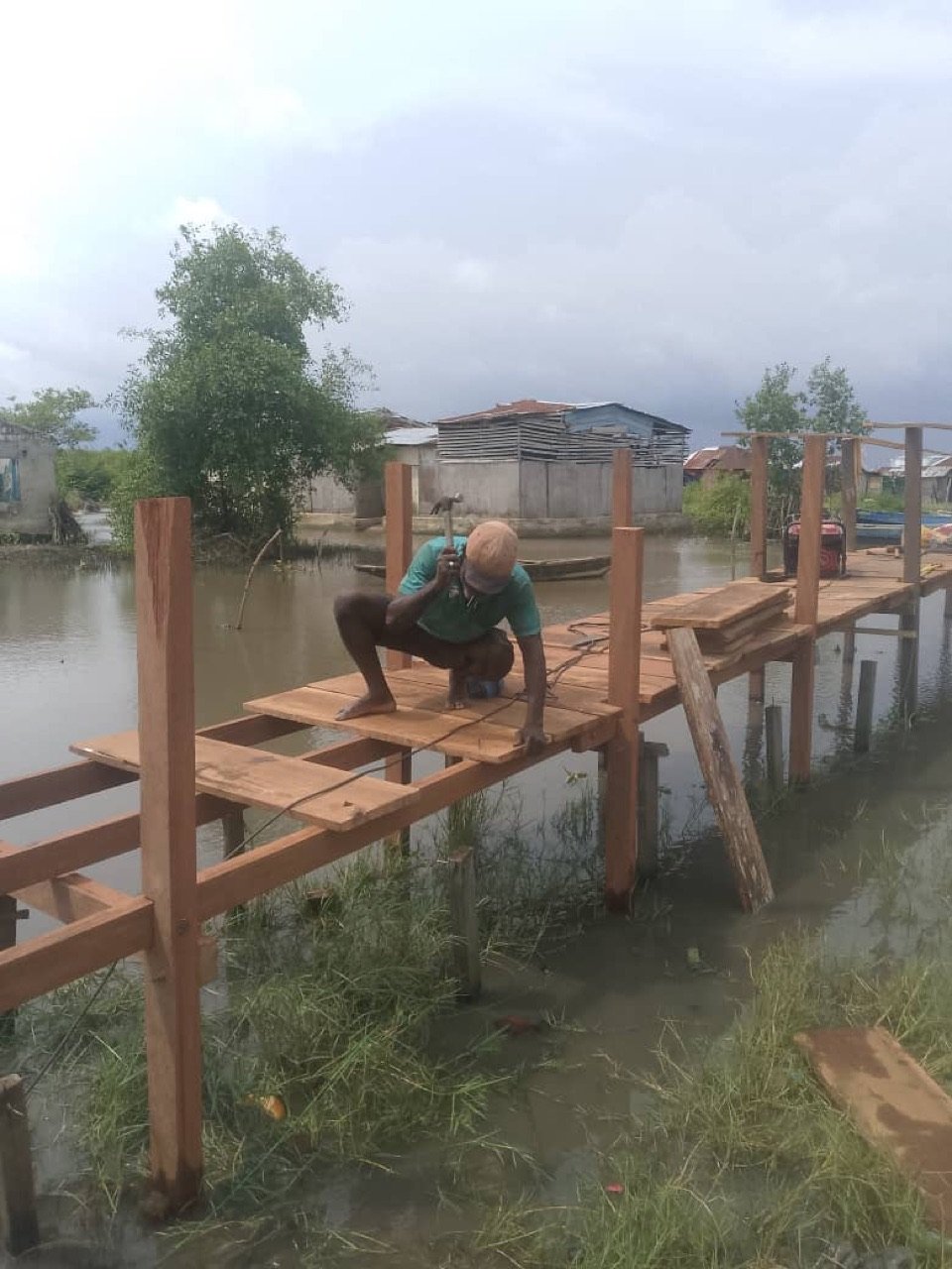 A carpenter fastening boards to the new bridge