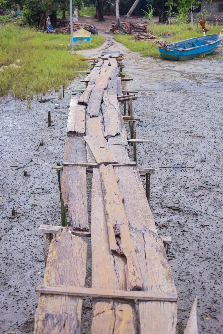 Worn, uneven planks on the old bridge in Aloro Community